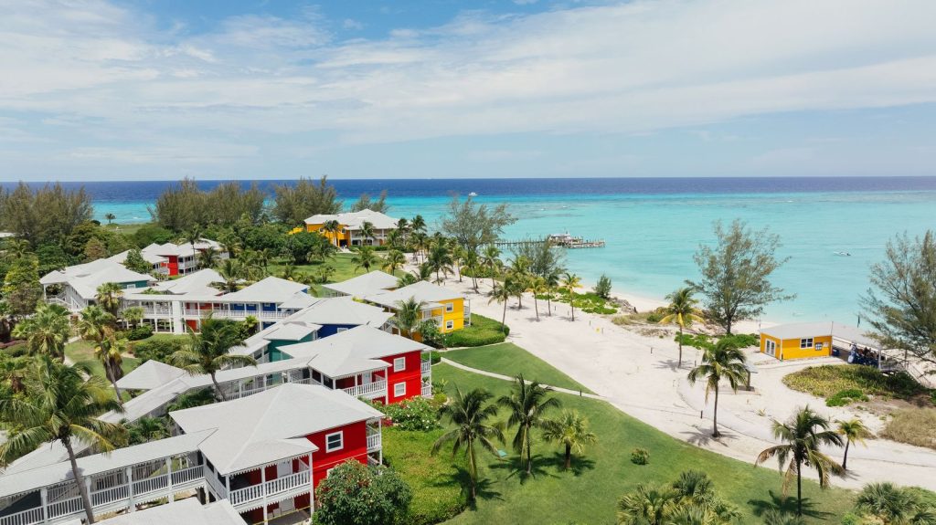Vue aérienne du Club Med Columbus Isle, ses bungalows colorés et sa plage turquoise aux Bahamas