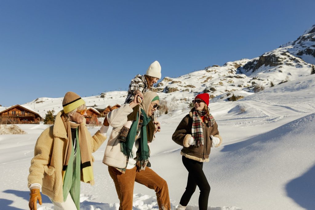 Amis qui rient dans la neige lors d’un séjour Club Med à la montagne
